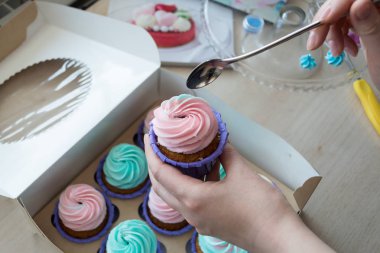 Cupcake cupcakes, flatlay bir kutu arka plan üzerine bir kaşık elinde