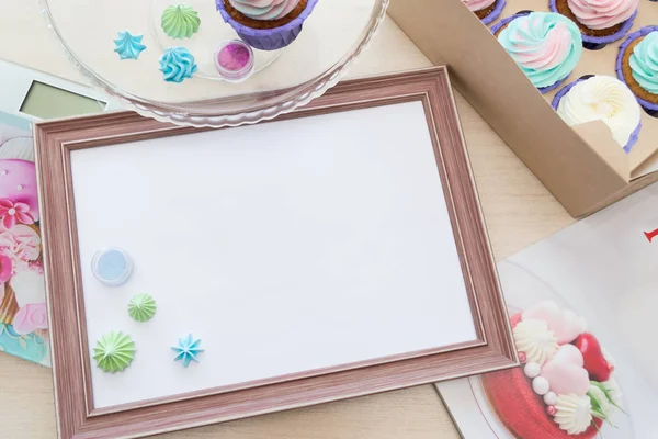 beze ve cupcake çok renkli krem, mutfak terazisi, dergi etrafında beyaz levha ile ahşap çerçeve