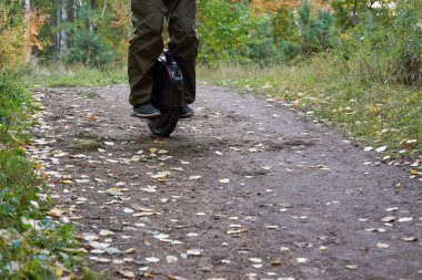 Adam bir monocycle üzerinde iz aşağı sürmek. tek tekerlekli bisikleti kapatın.