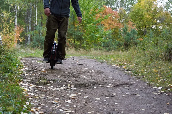 Adam bir monocycle üzerinde iz aşağı sürmek. tek tekerlekli bisikleti kapatın.
