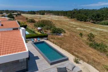 Bahçe havuzu ve ahşap güvertesi olan modern bir ev.