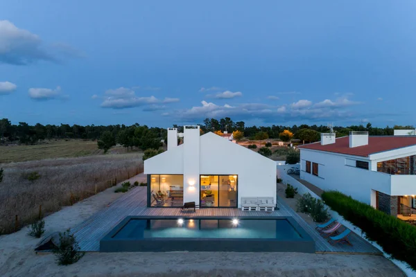 Bahçe havuzu ve ahşap güvertesi olan modern bir ev.