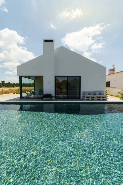 Bahçe havuzu ve ahşap güvertesi olan modern bir ev.