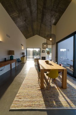 Bahçe havuzu ve ahşap güvertesi olan modern bir ev.