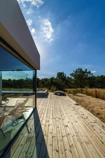 Bahçe havuzu ve ahşap güvertesi olan modern bir ev.