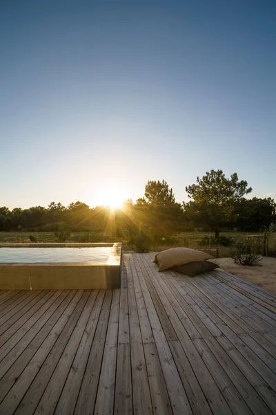 Bahçe havuzu ve ahşap güvertesi olan modern bir ev.