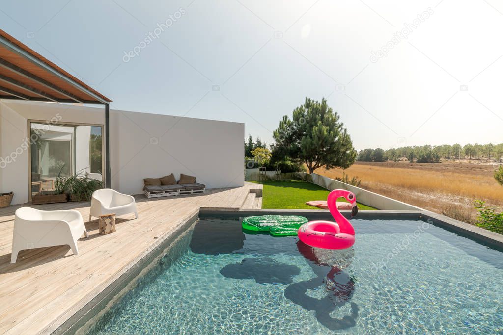 Modern house with garden swimming pool and wooden deck