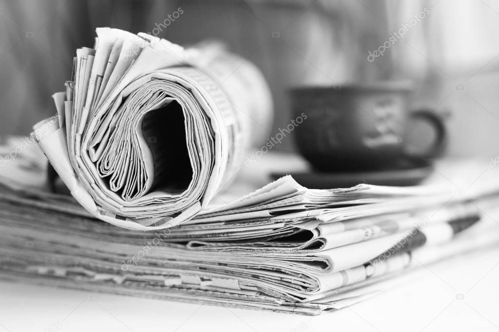 Newspapers and cup of tea, side view  