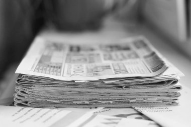 Taze sabah gazeteleri ofisindeki masanın üzerine yığını. Son mali ve iş Haberler günlük gazetede. Sayfaları bilgiler (başlıkları, makaleler, fotoğraflar, metin). Katlanmış ve yığılmış günlükleri