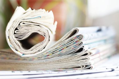 Haddelenmiş ve katlanmış Gazeteler yığın masanın üstüne yığılmış. Tabloid gazete başlıkları ve office masada makaleler ile. İletişim ve bilgi için kavram  