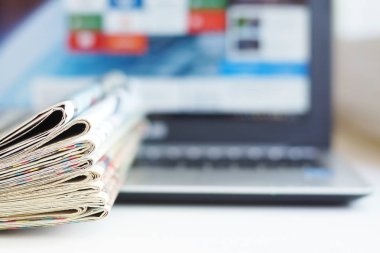 Gazeteler ve bilgisayar. Dizüstü bilgisayar ve günlük kağıtları masaya. Taze haber kağıt veya elektronik aygıt, iletişim farklı yollarını. Bilgi, gerçek veri sayfaları veya ekran kaynağı  