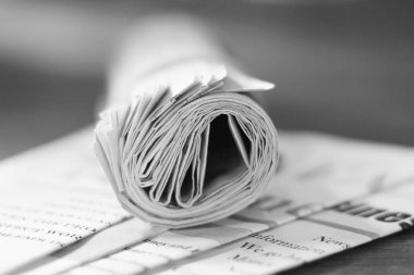 Gazeteler. Haddelenmiş günlük haber ve sayfa başlıkları ve makaleler, yan görünüm, seçici odak ile