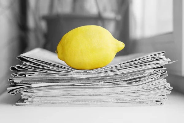 Stack of newspapers and lemon. Daily journals with headlines and articles and fresh fruits. Concept for juicy news