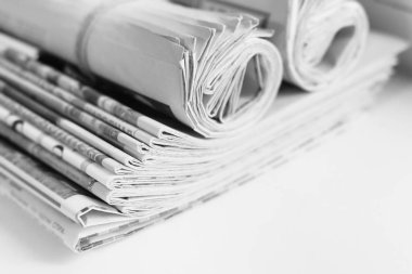Taze sabah gazeteleri ofisindeki masanın üzerine yığını. Son mali ve iş Haberler günlük gazetede. Sayfaları bilgiler (başlıkları, makaleler, fotoğraflar, metin). Katlanmış ve yığılmış günlükleri 