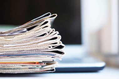 Açık laptop ve Gazeteler yığını. Günlük günlüklerin haber ve kişisel bilgisayar ile. Kavramı için farklı bilgi kaynakları - dijital cihaz ekran veya kağıt sayfaları