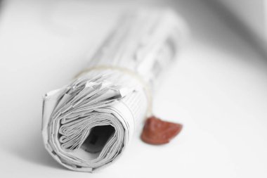 Gazete sabah haber için kavram olarak beyaz masaya yuvarlandı 