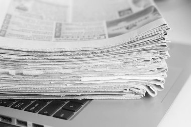 Açık laptop ve Gazeteler yığını. Günlük günlüklerin haber ve kişisel bilgisayar ile. Kavramı için farklı bilgi kaynakları - dijital cihaz ekran veya kağıt sayfaları