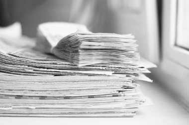 Gazeteler ve bohça-in para, yan görünüm yığını               