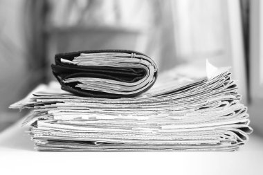 Gazeteler bir sürü üst üste yığın ve cüzdanı para dolu. Finansal Haberler ve birçok banknot kağıtları. İş ve başarı için kavram