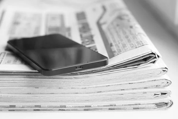 Gazeteler ve smartphone. Tabloid dergi ve cep telefonu - iş kavramı. Katlanmış ve kazık ve mobil gadget'ı yığını, seçici odak büyüğe haber dergileri