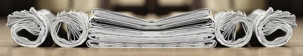 Long horizontal banner with rolled and folded newspapers and magazines in retro style. Concept for news and information - could be used for web design or advertisement