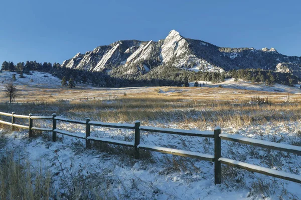 Chautauqua Park in winter with the snow-covered flatirons on Green Mountain just after sunrise in Boulder, Colorado.