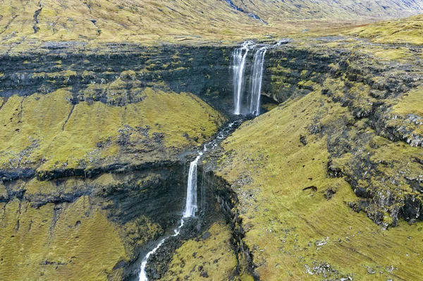 Aerial view of Fossa Waterfall, the highest waterfall in the Faroe  Islands. This double-tiered waterfall is 459 feet high and cascades down into the sea.
