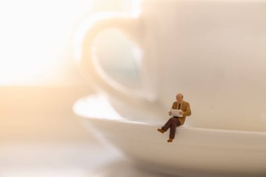 Okuma, rahatlatıcı, hobi konsepti. İşadamı miniat yakın çekim