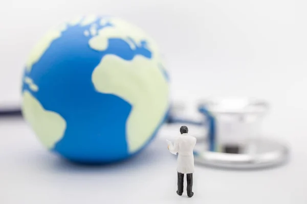 Global Health Care Concept. Close up of doctor miniature figure