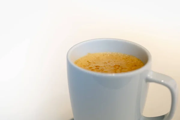 Nahaufnahme einer weißen Tasse heißen Kaffees mit Blase. — Stockfoto
