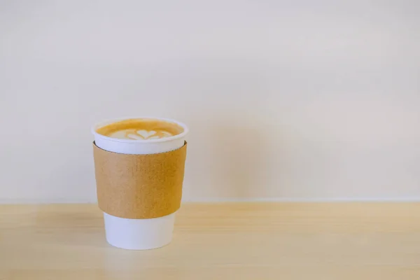 Κλείστε το χάρτινο φλιτζάνι του ζεστού καφέ λάτε με την καρδιά του αφρού του γάλακτος — Φωτογραφία Αρχείου