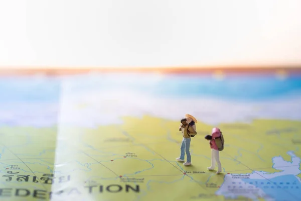 Travel Concept. Man and woman traveler miniature figures with ba