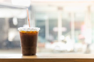 Lokantada, ahşap masada fotokopi sapıyla birlikte plastik buzlu kahve fincanını kapat..