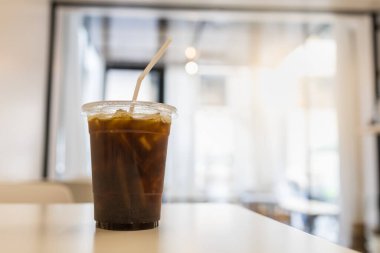 Lokantada, ahşap masada fotokopi sapıyla birlikte plastik buzlu kahve fincanını kapat..