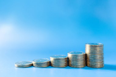 Para, İş ve Risk Konsepti. Mavi arkaplanda kopyalama alanı olan bozuk para yığınını kapat.