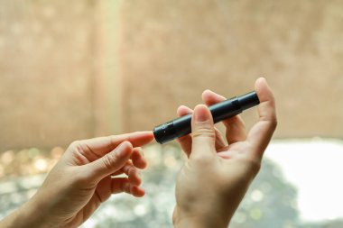 Kan şekeri seviyesini Glikoz ölçer ile ölçmek için kadın ellerini parmak üzerinde mızrak kullanarak kapat. İlaç, diyabet, glisemi, sağlık hizmetleri ve insanların konsepti olarak kullan.