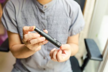 Kan şekeri seviyesini Glikoz ölçer ile ölçmek için kadın ellerini parmak üzerinde mızrak kullanarak kapat. İlaç, diyabet, glisemi, sağlık hizmetleri ve insanların konsepti olarak kullan.