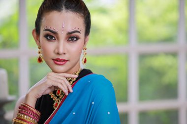 Asyalı güzel bir Taylandlı kızın portresi. Kundan mücevher seti olan genç Hindu kadın model. Geleneksel Hindistan kostümü mavi sari ve lehenga elbise.