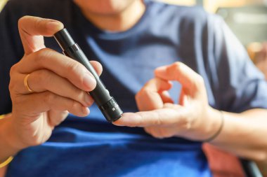 Kan şekeri seviyesini Glikoz ölçer ile ölçmek için parmağa mızrak kullanarak insan elini kapat. İlaç, diyabet, glisemi, sağlık hizmetleri ve insanların konsepti olarak kullan.