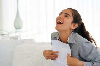 Genç kadının yazılı olarak iyi haber. Kız kanepede oturan iyi haber ile bir mektup okur. Bir euphoric yazılmış bir mektupta, iyi haber okuduktan sonra bir kredi onaylama mutlu bir kızdır.