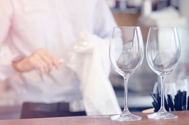 Barmen şarap bardakları siliyor. Garson şarap bardakları siliyor. Barmen cam temizler. Şarap bardakları üzerinde odaklanın. Hizmet kavramı. Tonlama