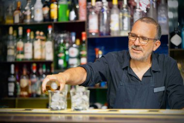 Barmen adam viski otel barının istemciye dökülen. Hizmet kavramı. Barmen üzerinde odaklanmak.