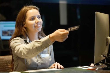 Oda anahtarı için yeni müşteriler verici bir gülümseyen kadın-Resepsiyon işçi otel müdürü. Profili bir Otelin resepsiyonunda çekici Yöneticiler bir kadeh. Hizmet kavramı.