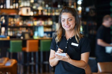Bir barmen otel restoranında müşterinin sipariş alır. Öğle yemeği zamanı. Şirin kız gülümsüyor. Bir kız Garsonlar bir emir alır. Hizmet kavramı.