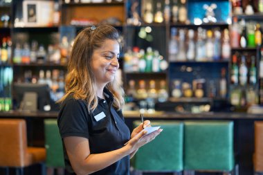 Bir barmen otel restoranında müşterinin sipariş alır. Öğle yemeği zamanı. Şirin kız gülümsüyor. Bir kız Garsonlar bir emir alır. Hizmet kavramı.