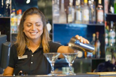 Profesyonel barmen kız taze kokteyl müşterilere otel barının dökülen. Hizmet kavramı. Barmen üzerinde odaklanmak.