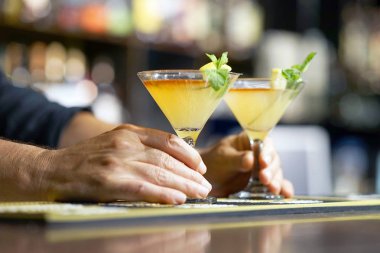 Barmen bir kokteyl otel barının istemciye verir. Taze kokteyl ile portakal. Alkollü, alkolsüz içki-içecek barda gece kulübüne karşı. Limon kokteyl bardak.