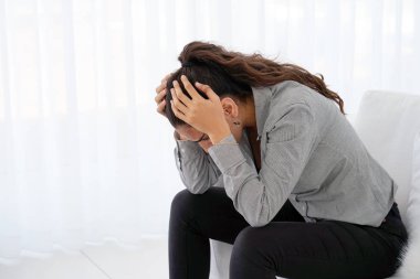 Baş ağrısı migren ağrısı evde kanepe üzerinde acı bir kadın. Sağlık sorunu, stres ve depresyon. Erkek el ile kafa tutar. Sağlık kavramı.