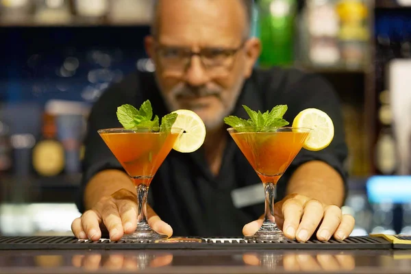 Barmen bir kokteyl otel barının istemciye verir. Taze kokteyl ile portakal. Alkollü, alkolsüz içki-içecek barda gece kulübüne karşı. Greyfurt kokteyl bardak.