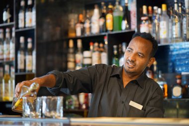 Barmen adam viski otel barının istemciye dökülen. Hizmet kavramı. Barmen üzerinde odaklanmak.